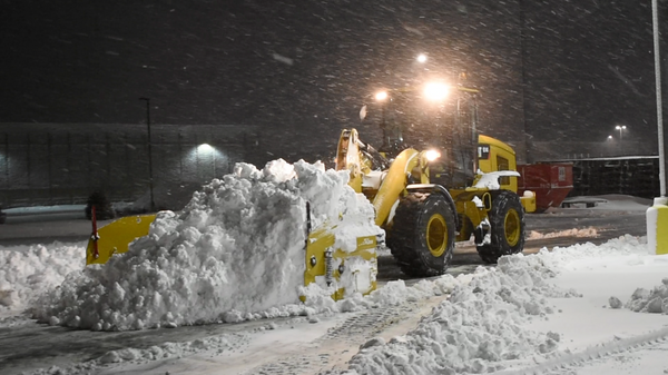 Metal Pless Maxxpro with live edge pushing a large snow pile at night
